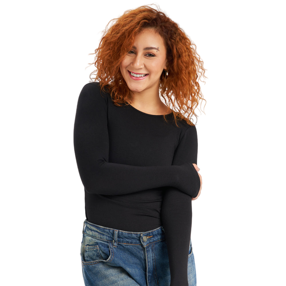 Person wearing a black long-sleeve top and blue jeans on a light gray background